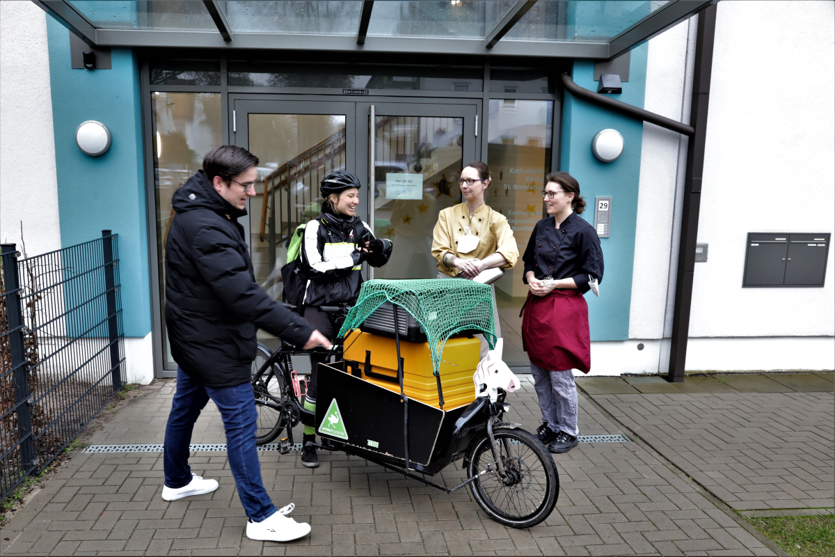 Gruppenbild mit (von links): Christopher Peiler, Geschäftsführer des Katholischen Gemeindeverbands in Bremen, Fahrradkurierin Lesmona Kapscha sowie Nadine Bösche und Nina Kuhlmann von der Küche der Kita St. Bonifatius in Findorff. - Foto: Christof Haverkamp